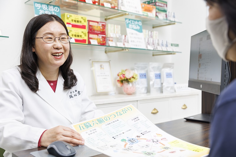中医師(中医学アドバイザー)として誠心堂薬局の店頭で相談受付する蔄先生